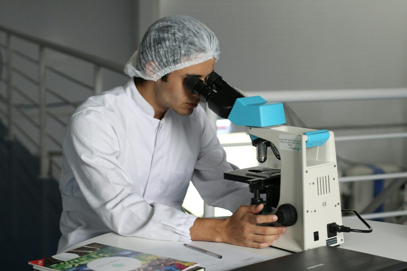 Photo by Lucas Vasques man sight on white microscope