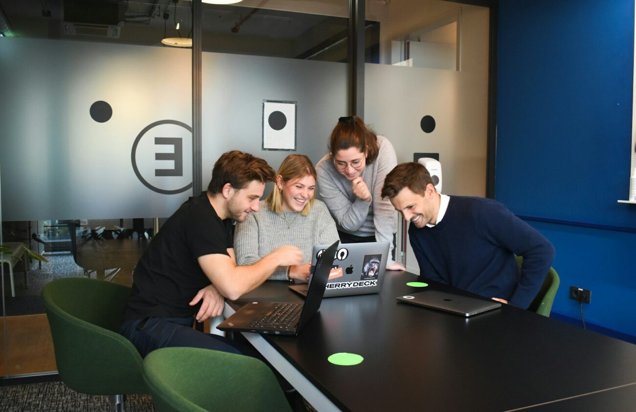 Features 9 people sitting on chair in front of laptop computers