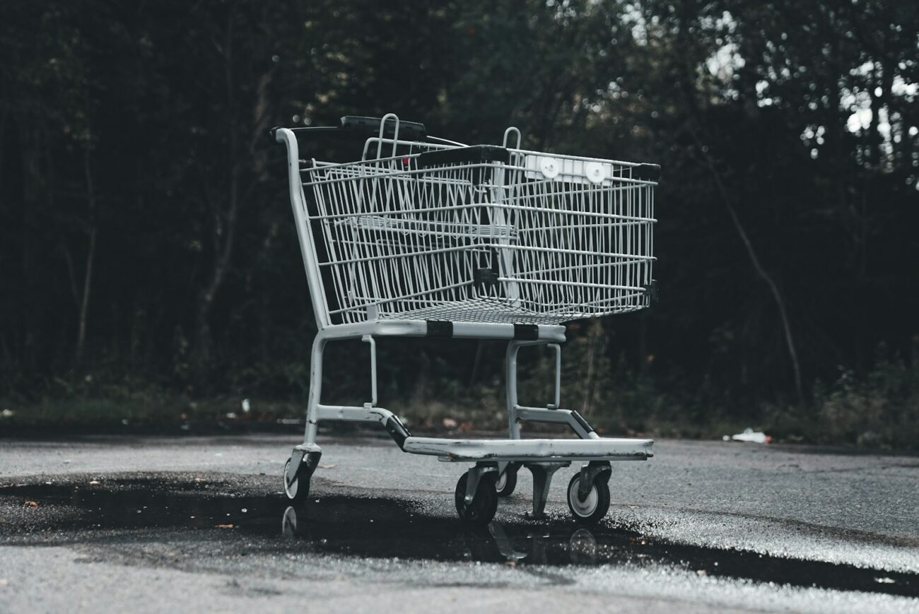 A shopping cart sitting on the side of a road